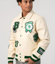 Load image into Gallery viewer, Person wearing a cream-colored varsity jacket with green and black designs on a plain background

