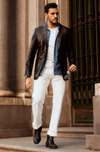 Load image into Gallery viewer, Man in stylish outfit with leather jacket, white pants, and black shoes standing in front of classical architecture.
