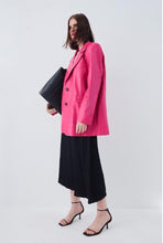 Load image into Gallery viewer, Woman wearing a bright pink coat over a black dress

